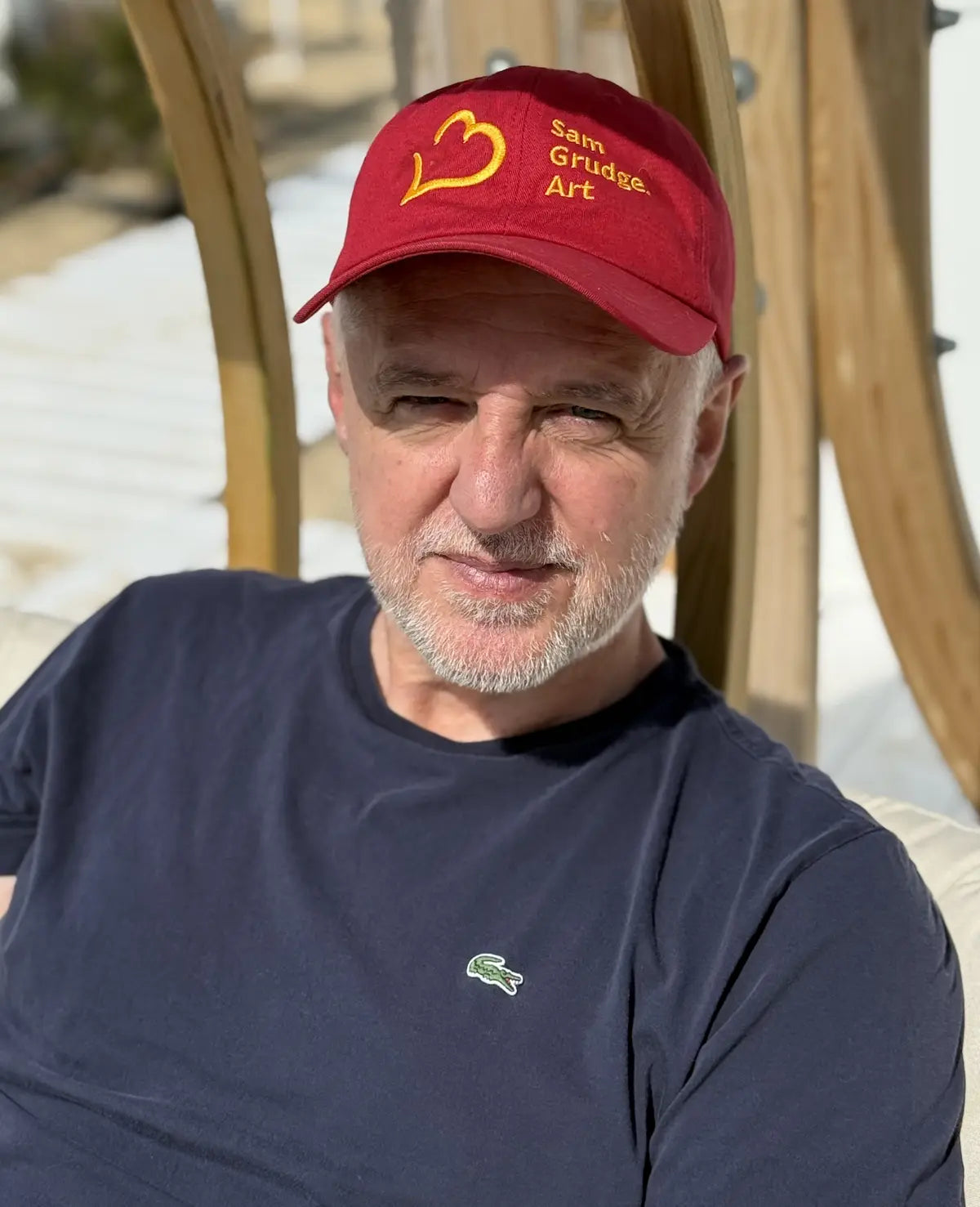 Sam Grudge outdoors, wearing his red Sam Grudge Art cap.