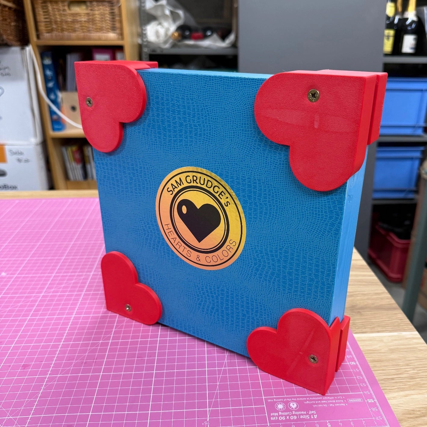 Sam’s custom blue wooden shipping crate with red heart-shaped corner protectors