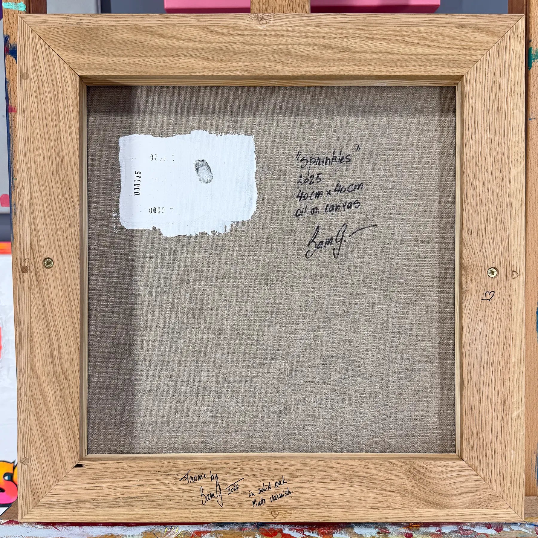 A handmade solid-oak frame, with Sam’s writing and stamps alongside the painting’s own marks.